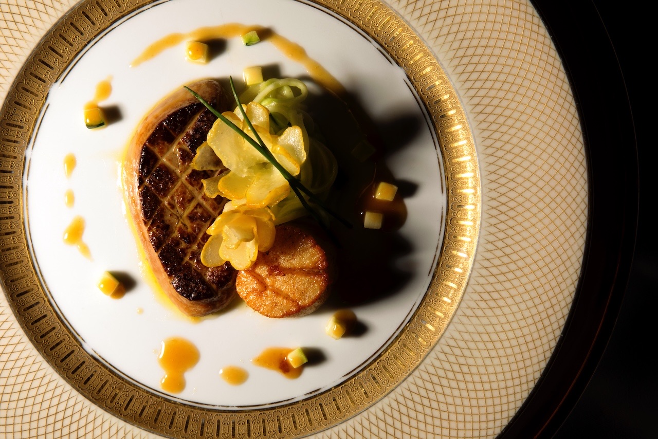 Seared foie gras and scallop on a gold-rimmed plate
