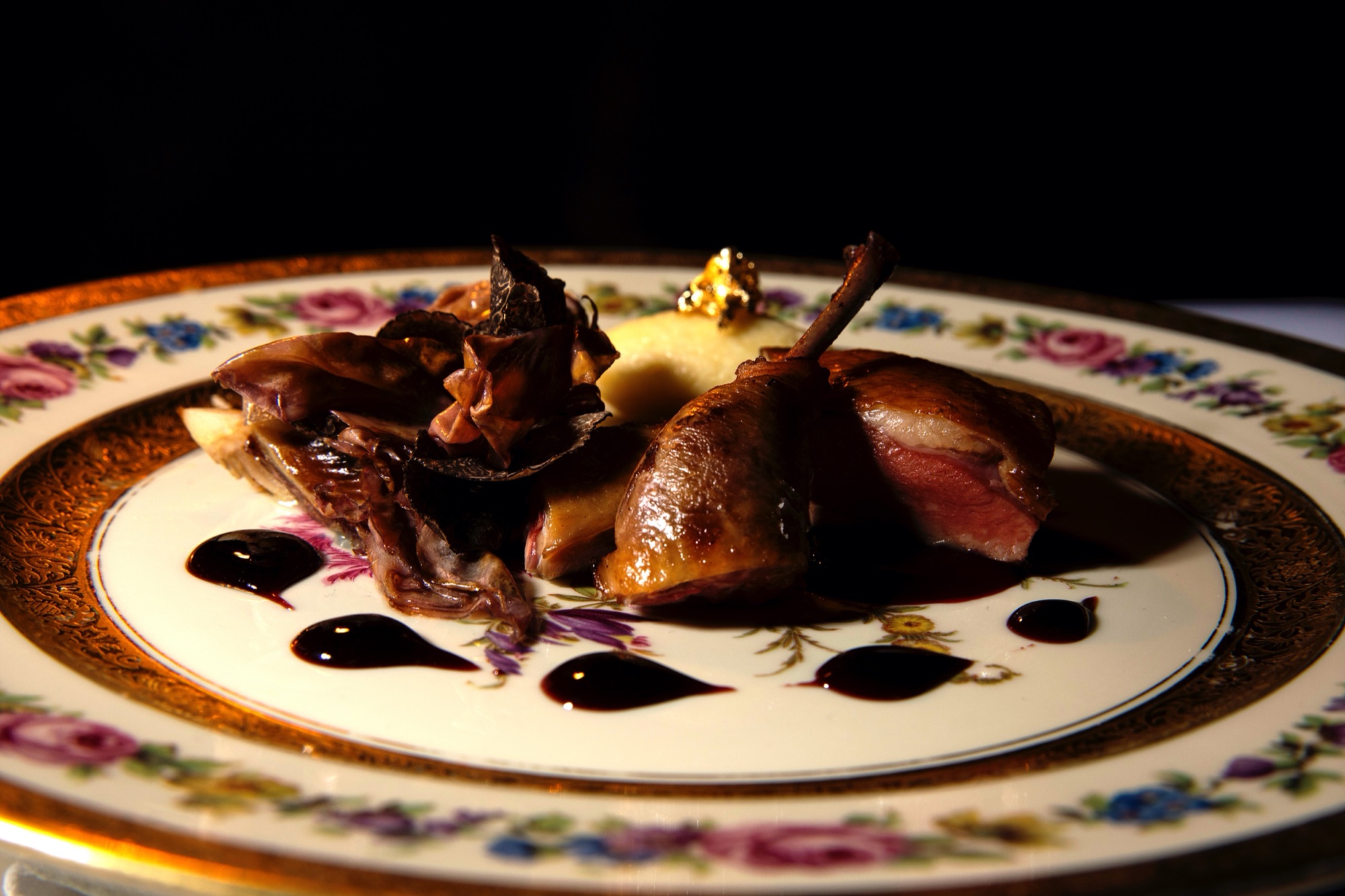 Roasted pigeon on gilt-edged china